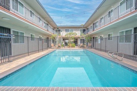 A swimming pool in a residential area surrounded by buildings.