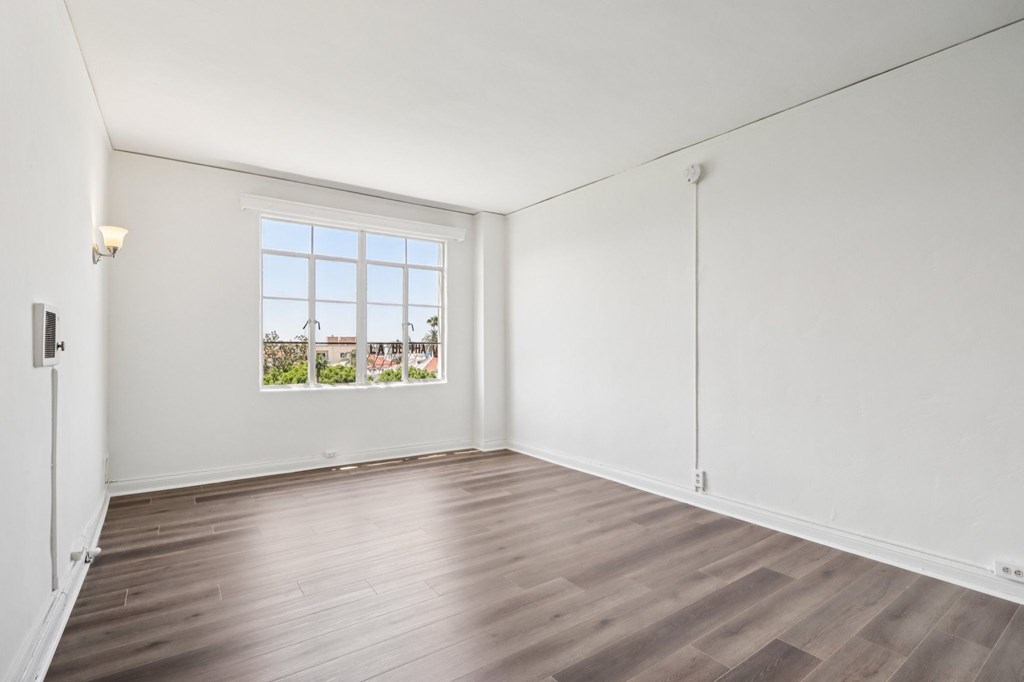 A room with a window and wooden flooring.