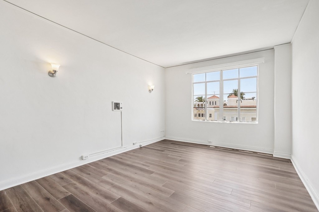 A room with a large window overlooking a residential area.