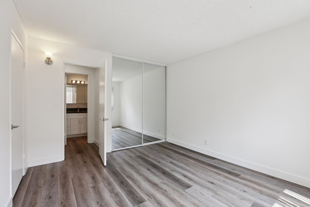 A room with a white wall and a wooden floor.
