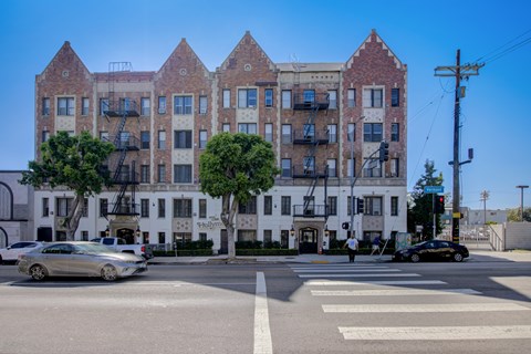 A street view of a large white building with a sign that reads
