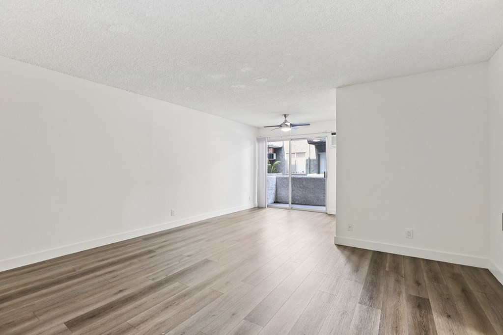 A room with wooden flooring and a ceiling fan.