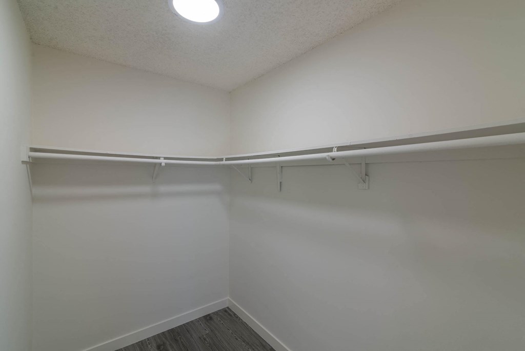 the closet of an empty room with white walls and a white curtain