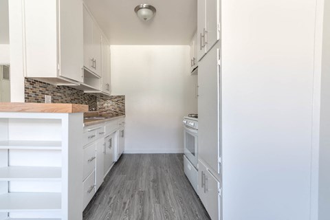 A kitchen with white cabinets and a tile backsplash.