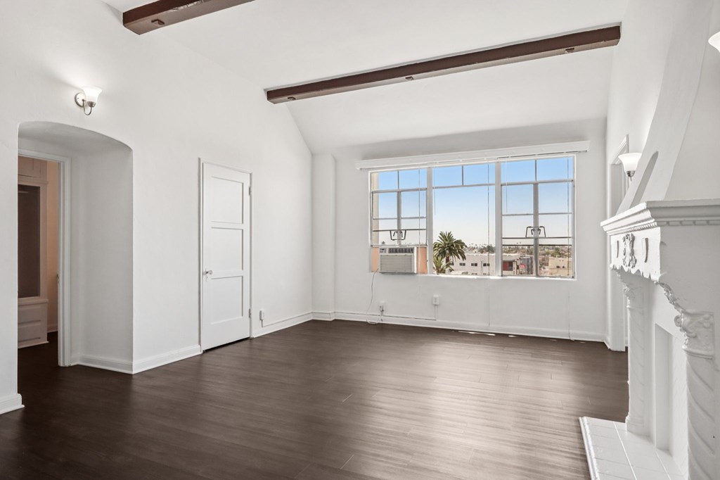 A large empty room with a window overlooking a cityscape.