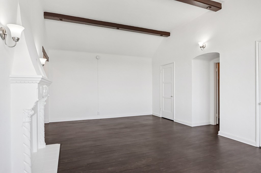 A room with white walls and wooden floors.