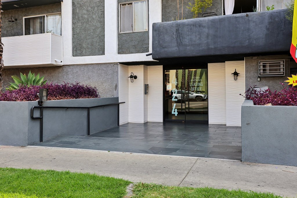 A modern house with a grey front yard and a black gate.