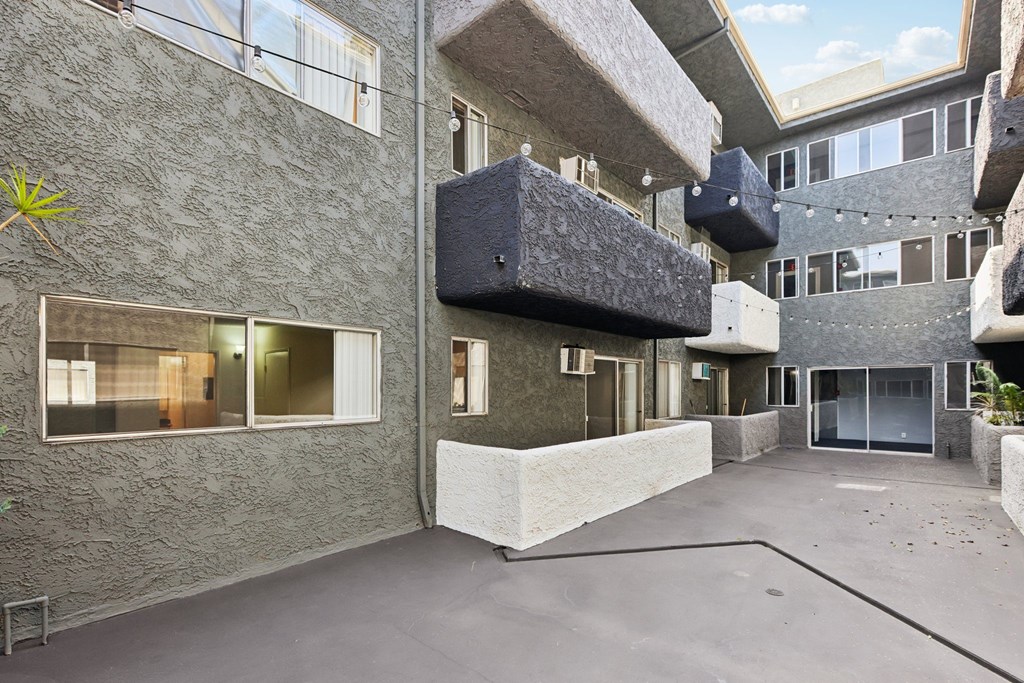 A courtyard surrounded by buildings with a concrete floor.