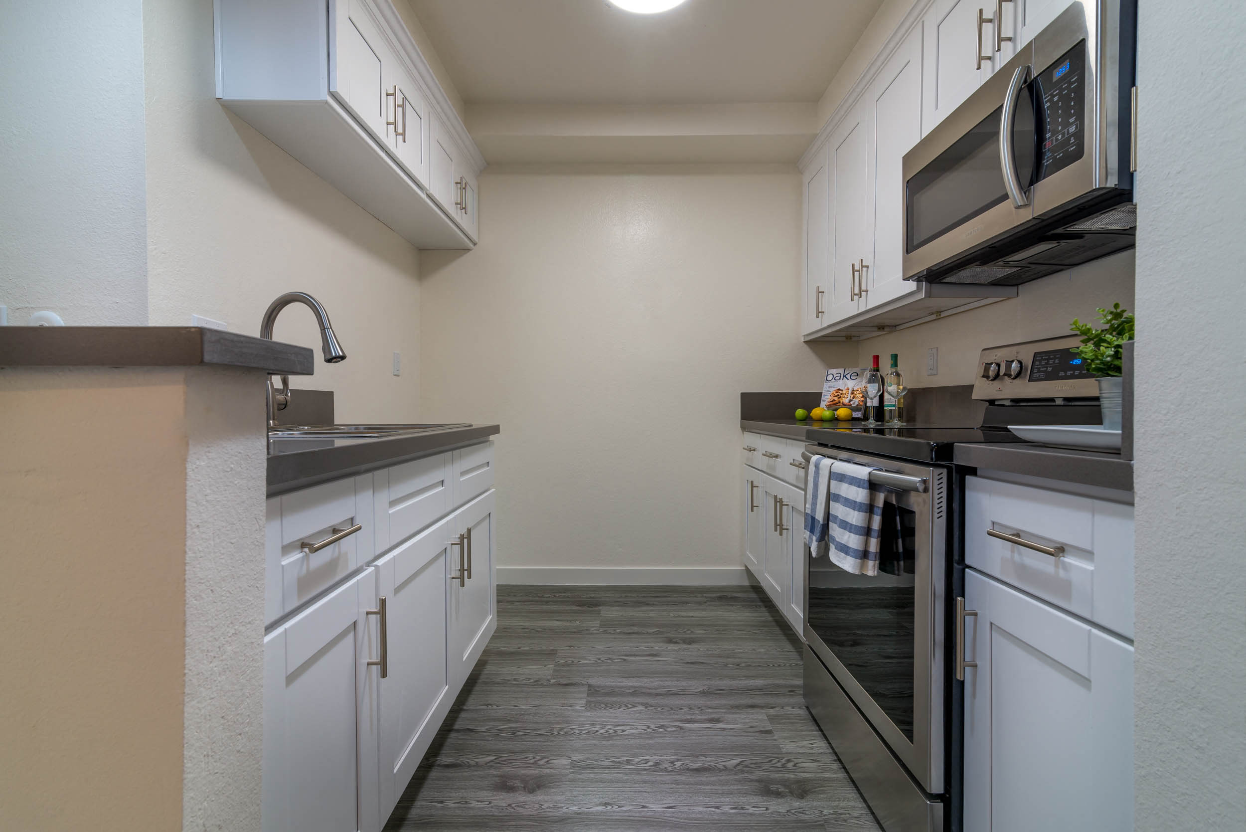 A kitchen with white cabinets and a black stove top oven.