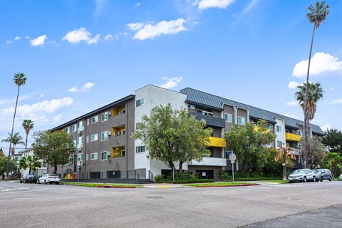 A modern apartment building with a parking lot in front.