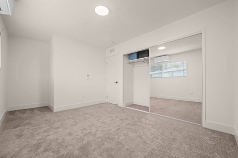 a white room with a white cabinet and a window