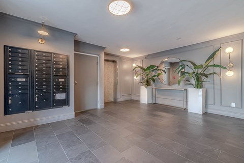 A spacious room with a grey floor and a black cabinet on the wall.