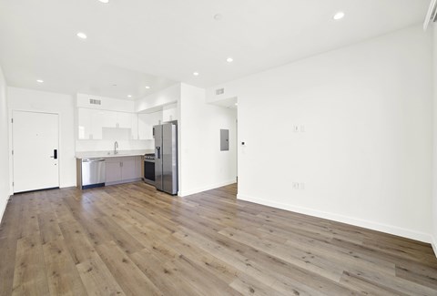 A kitchen with a refrigerator, sink, and cabinets is visible.