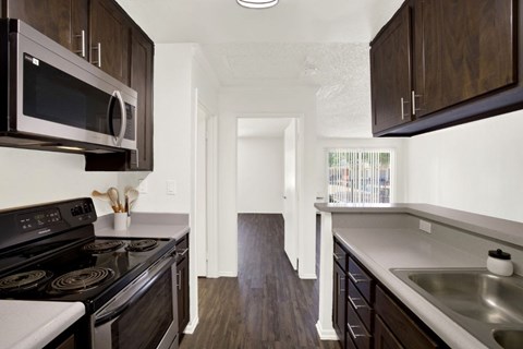 A kitchen with dark wood cabinets and stainless steel appliances.