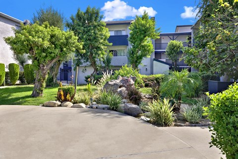 A residential area with a well-maintained garden and apartment buildings.
