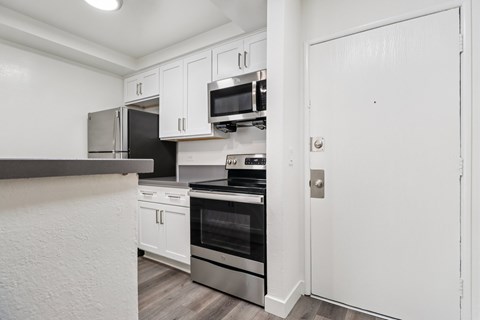 A kitchen with white cabinets and stainless steel appliances.
