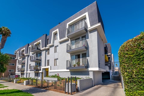 A modern apartment building with balconies and a clear blue sky.