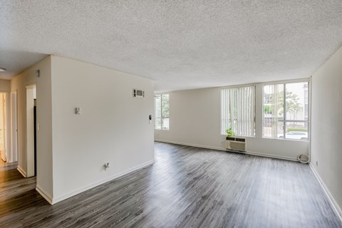 A large empty room with wooden floors and white walls.