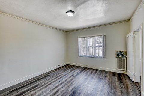 A room with a window and a wooden floor.