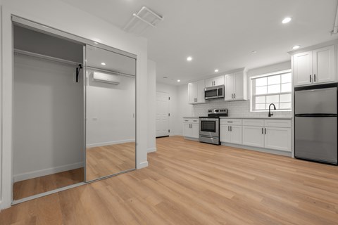 A kitchen with wooden floors and white walls.
