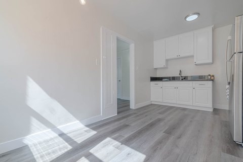 a renovated kitchen with white cabinets and a white refrigerator