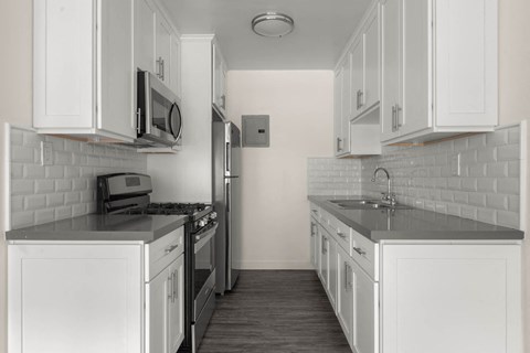 A kitchen with white cabinets and a black stove top oven.