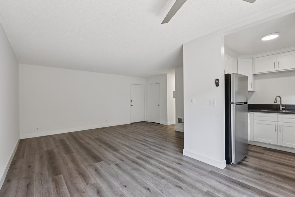 A kitchen with white cabinets and a refrigerator.