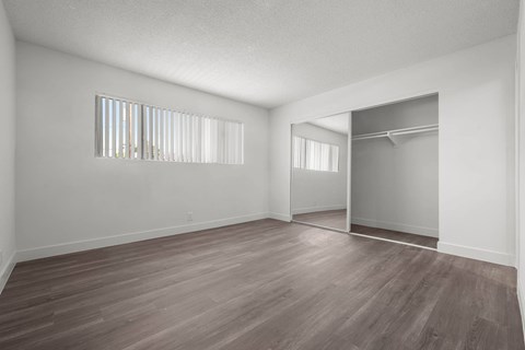 Empty room with wooden floor and white walls.