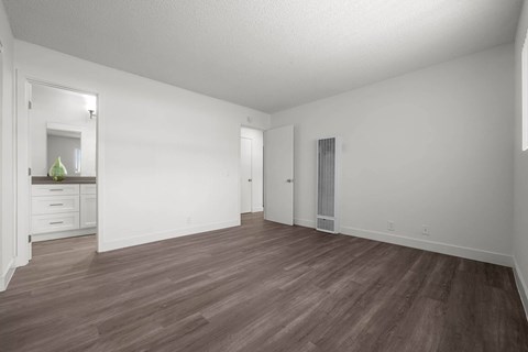 A room with wooden flooring and white walls.