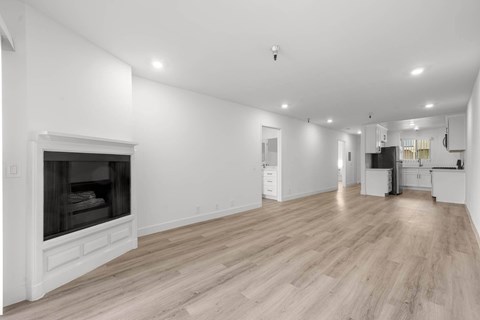 A spacious living room with a fireplace and hardwood floors.
