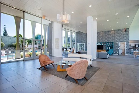 Modern lobby with seating area and floor to ceiling windows at Parc @ 5 Apartments, Downey, CA 90240