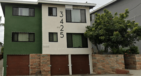 A green and white house with the numbers 3425 on the side.