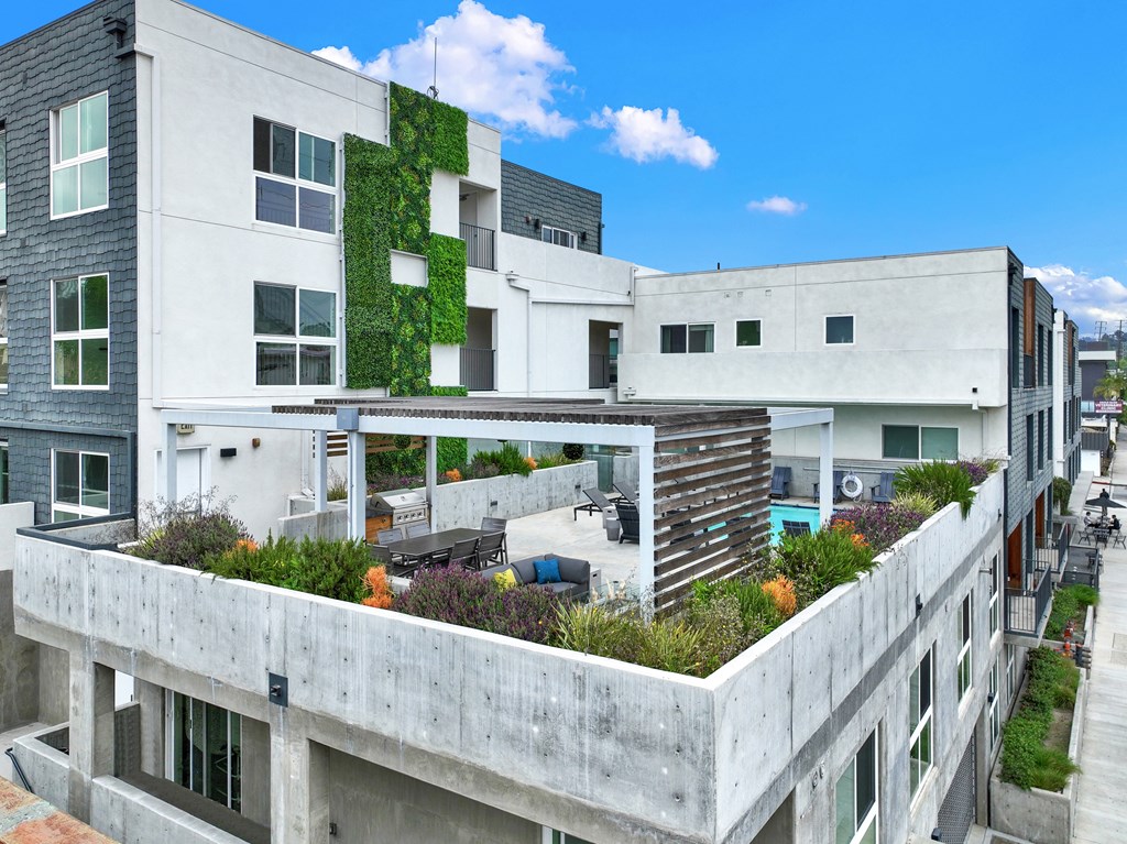 a view of a building with a roof terrace with plants