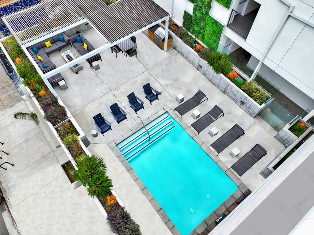 an aerial view of a swimming pool in front of an apartment building