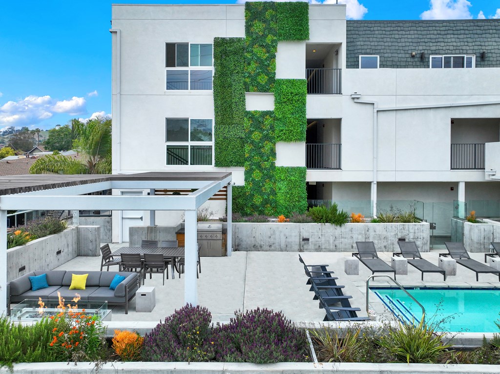 a white house with a swimming pool and patio furniture