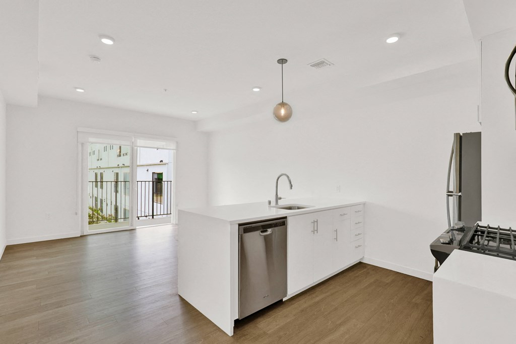 a large white kitchen with white cabinets and a stainless steel dishwasher