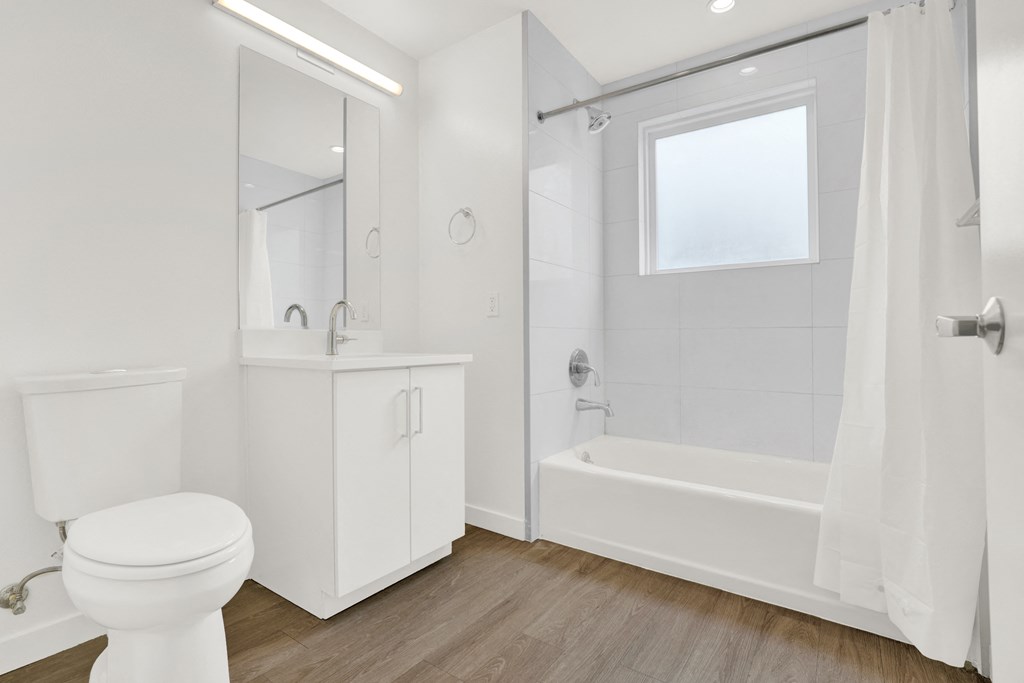 a bathroom with a toilet and a shower and a sink