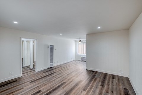 a living room with white walls and wood floors