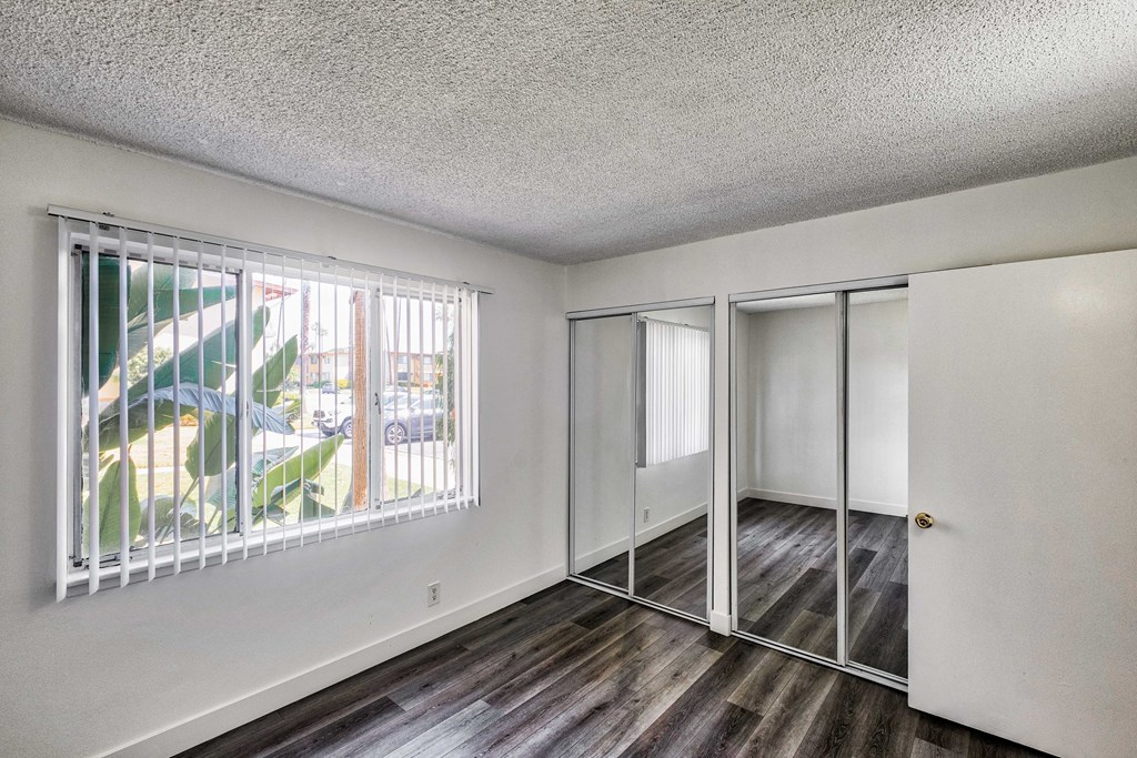 Bedroom view with mirrored closet doors at Serrano Apartments, West Covina, CA, 91790