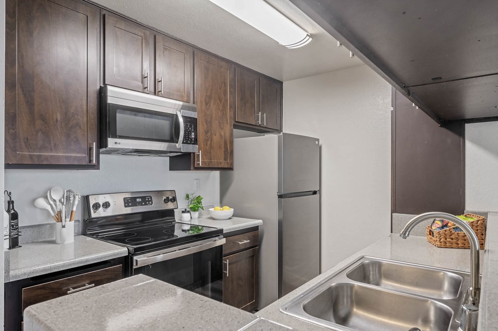 a kitchen with stainless steel appliances and wooden cabinets at Monterra Ridge Apartments, California,91351