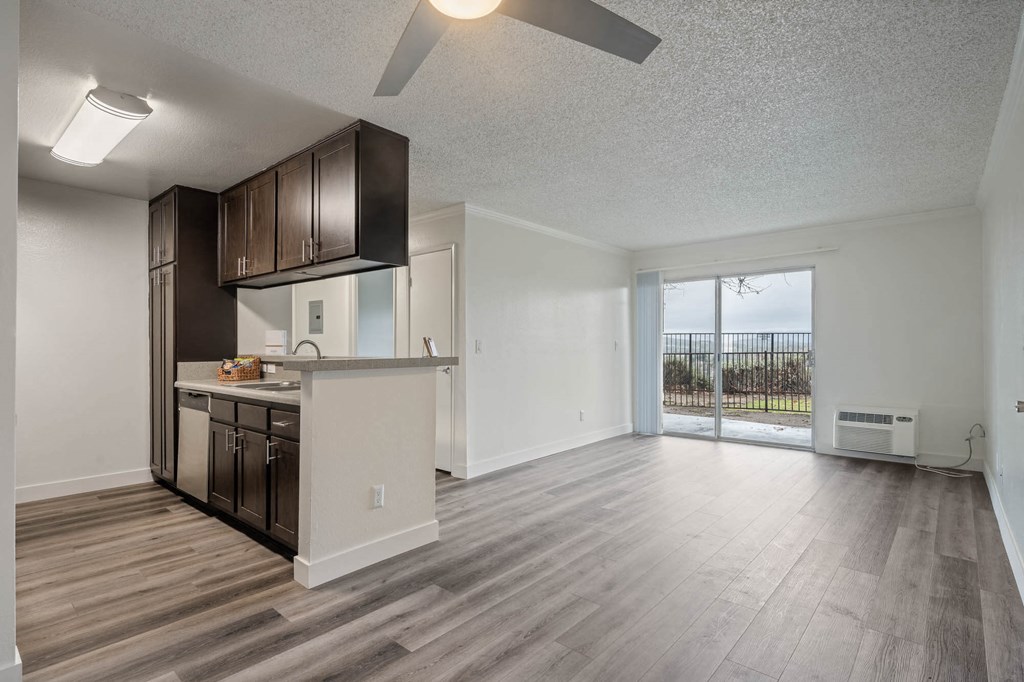 an open living room and kitchen with a sliding glass door to a patio at Monterra Ridge Apartments, Canyon Country, CA, 91351