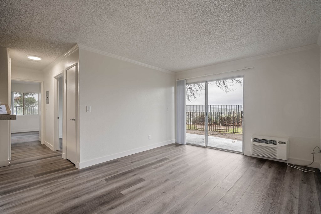 the living room and dining room of an empty house with wood flooring and a at Monterra Ridge Apartments, Canyon Country, CA