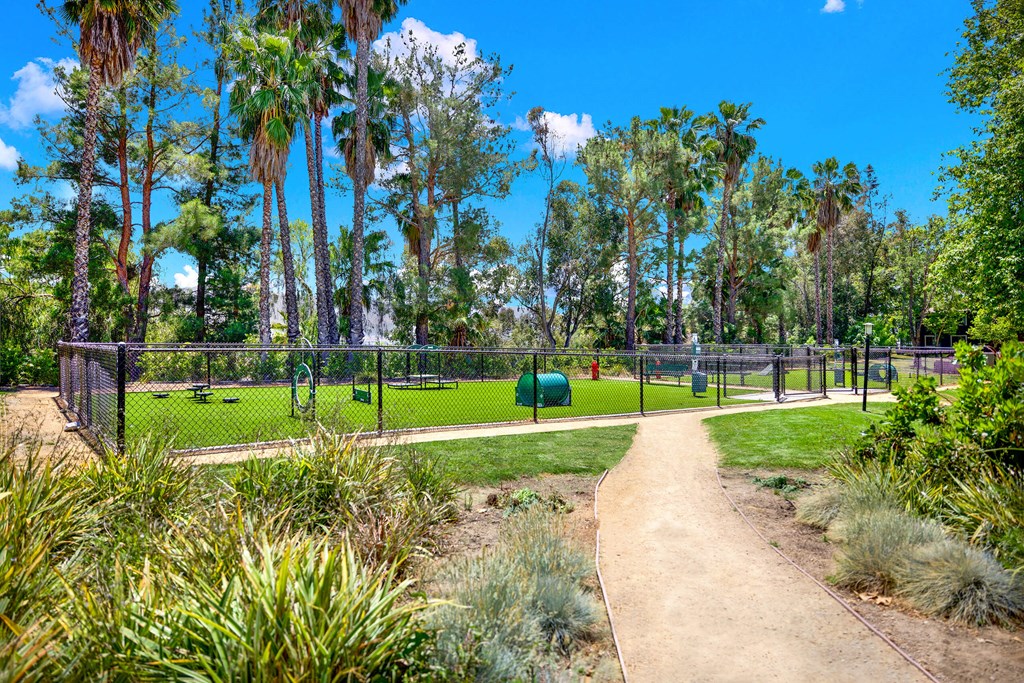 a path leading to a park with a playground and trees at Monterra Ridge Apartments,California