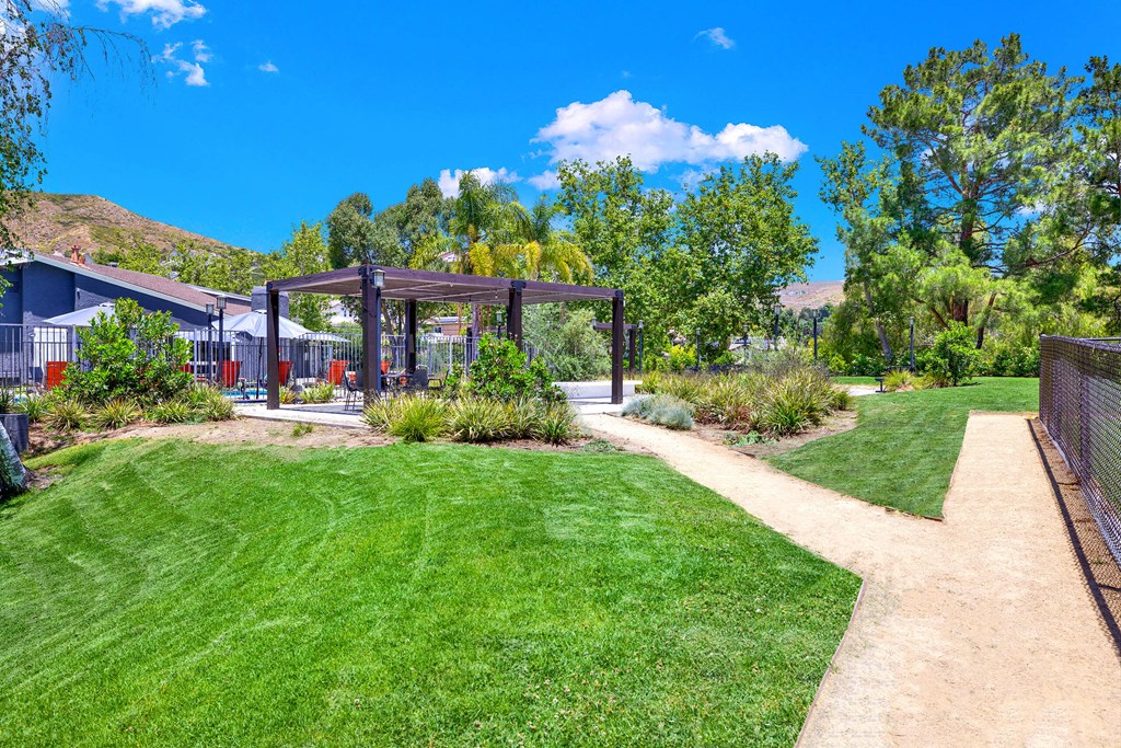 a path leading to a yard with a pergola at Monterra Ridge Apartments, Canyon Country ,91351