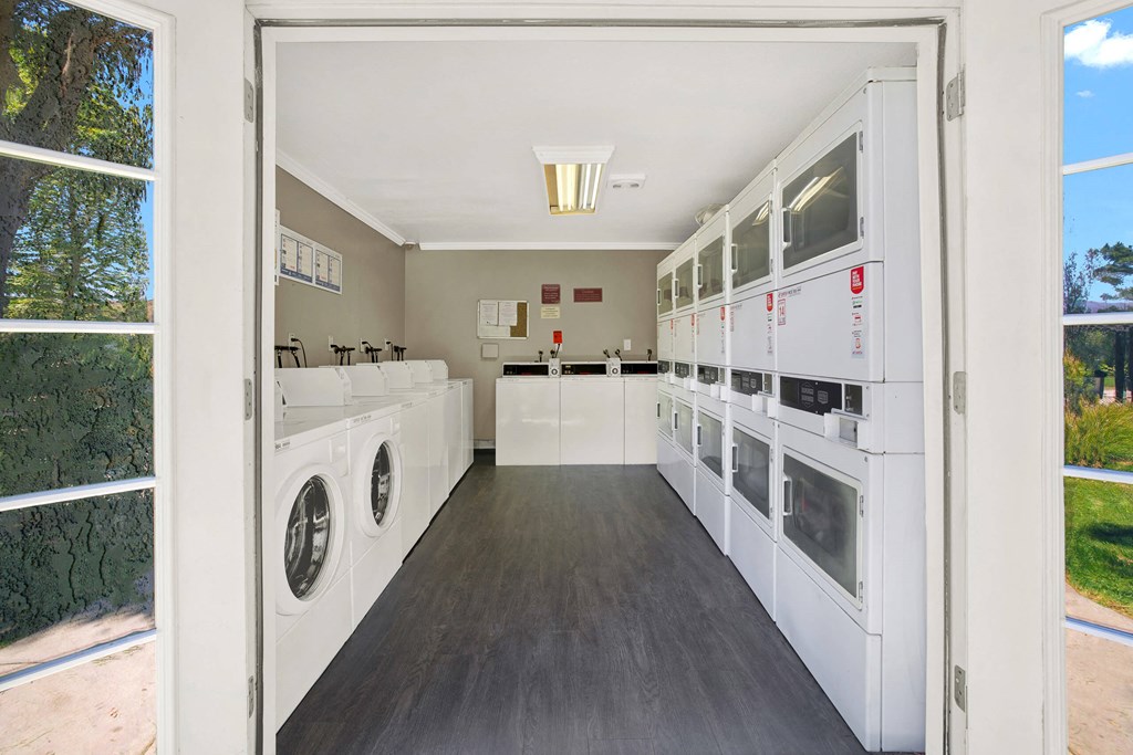 a laundry room with washers and dryers and a window at Monterra Ridge Apartments, California,91351