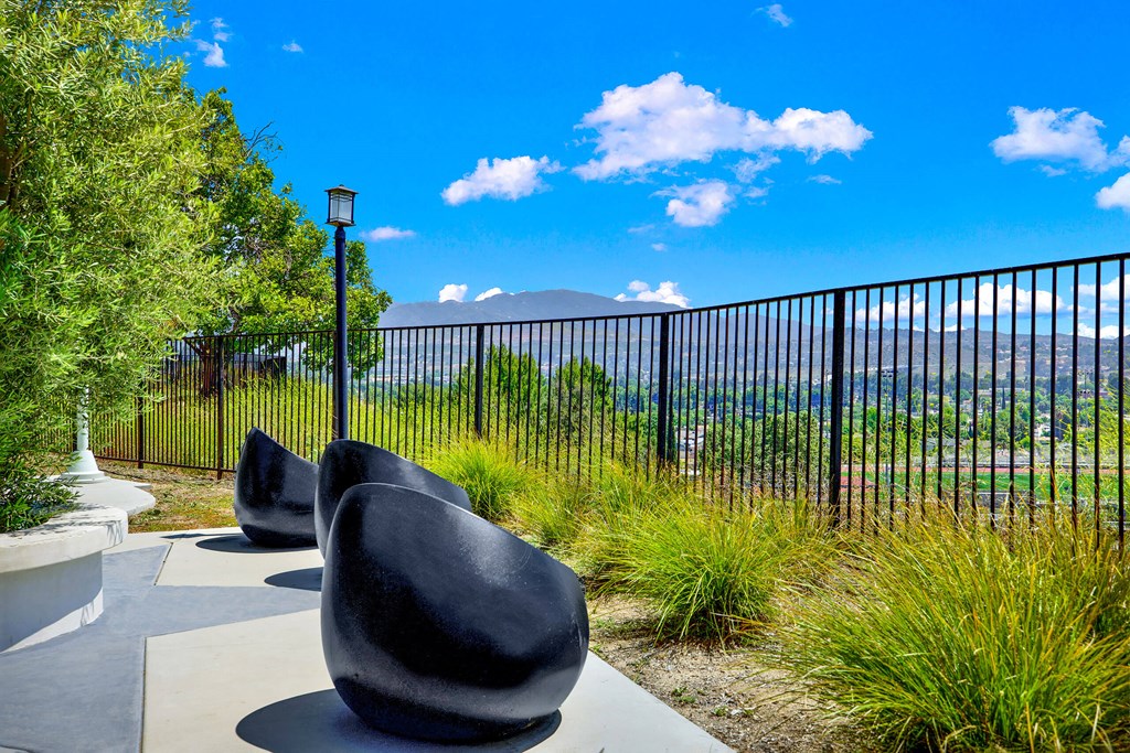 a group of chairs sitting in front of a fence at Monterra Ridge Apartments, Canyon Country ,91351
