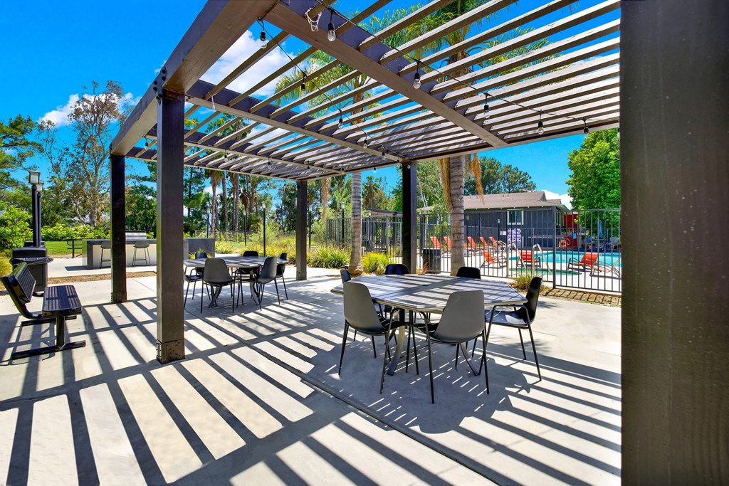 a patio with tables and chairs under awning at Monterra Ridge Apartments,California