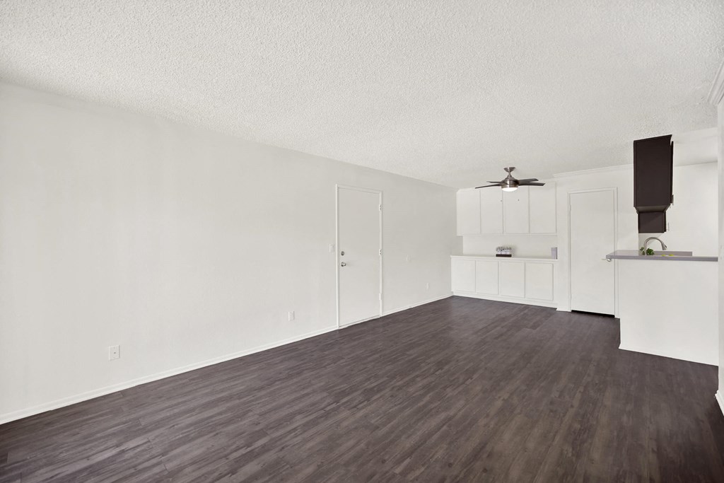 an empty living room with white walls and wood floors at Monterra Ridge Apartments, Canyon Country, California