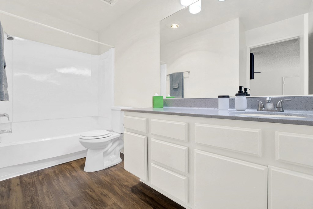 a bathroom with a large mirror and a toilet and a sink at Monterra Ridge Apartments, Canyon Country, California