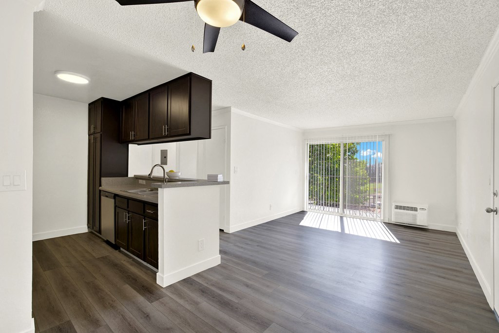 an empty kitchen and living room with a sliding glass door to a balcony at Monterra Ridge Apartments, California,91351